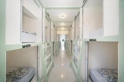 a hallway with multiple bunk beds in a room at Capsule Hostel and Thai Traditional Bath Bangkok in Bangkok
