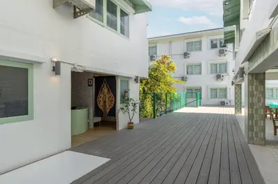 an empty courtyard of a building with white buildings at Capsule Hostel and Thai Traditional Bath Bangkok in Bangkok