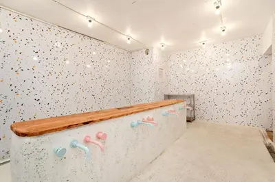 a bathroom with a wall covered in polka dots at Capsule Hostel and Thai Traditional Bath Bangkok in Bangkok