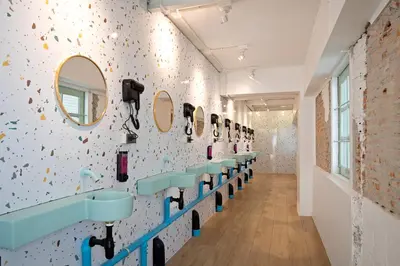 a bathroom with blue sinks and mirrors on the wall at Capsule Hostel and Thai Traditional Bath Bangkok in Bangkok