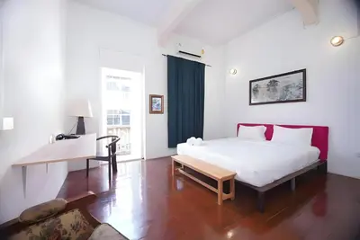 a bedroom with a bed and a desk in it at Mitr Inn Yaowarat - เยาวราช Pro in Samphanthawong
