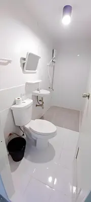 a white bathroom with a toilet and a sink at Mitr Inn Yaowarat - เยาวราช Pro in Samphanthawong