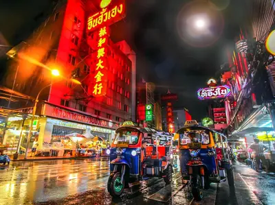 two motor scooters parked on a city street at night at Mitr Inn Yaowarat - เยาวราช Pro in Samphanthawong