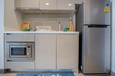 a kitchen with a refrigerator and a microwave at Dazzle Residence ByPinny2 in Bangkok