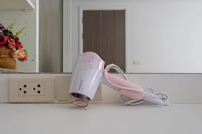 a pink wii remote sitting on a counter in front of a mirror at Dazzle Residence ByPinny2 in Bangkok