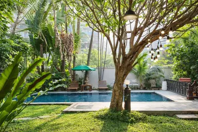 a swimming pool with a tree in a yard at Big 3 bedroom apartment Asoke in Bangkok