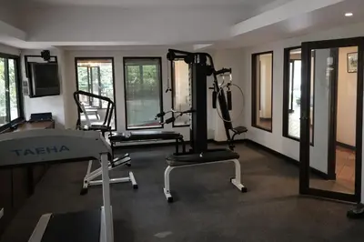 a gym with two tread machines and a television at Big 3 bedroom apartment Asoke in Bangkok