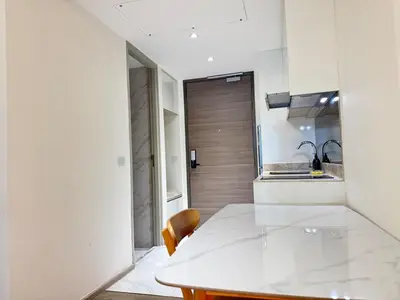 a white kitchen with a table and a sink at Fynn Bangkok Asoke Condo in Bangkok