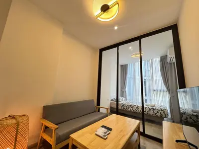 a living room with a couch and a table at Fynn Bangkok Asoke Condo in Bangkok