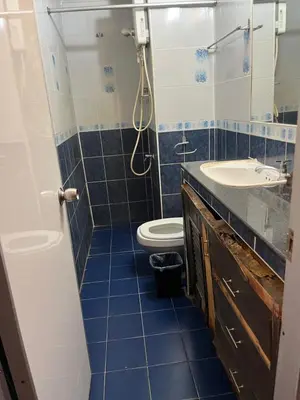 a blue tiled bathroom with a toilet and a sink at Impact Arena C4 by Jintana in Ban Bang Phang