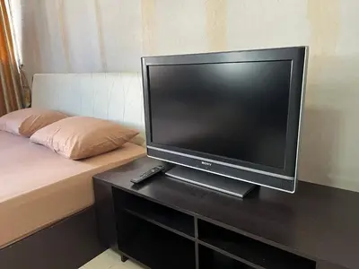 a flat screen tv sitting on a table next to a bed at Impact Arena C4 by Jintana in Ban Bang Phang