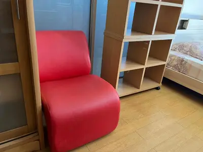a red chair in a room next to a bedroom at Impact Arena C4 by Jintana in Ban Bang Phang