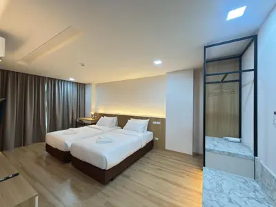 a bedroom with a large bed and a glass door at Armass Residence in Bangna