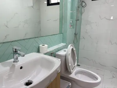 a bathroom with a sink and a toilet and a mirror at Armass Residence in Bangna