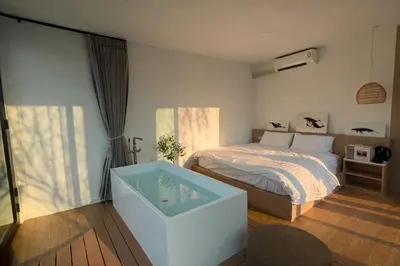 a bedroom with a bed and a tub in it at Feel Private Pool Villa in Ban Lam Praya Phai Rua