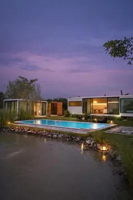a house with a swimming pool next to a river at Feel Private Pool Villa in Ban Lam Praya Phai Rua