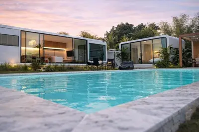 an exterior view of a house with a swimming pool at Feel Private Pool Villa in Ban Lam Praya Phai Rua