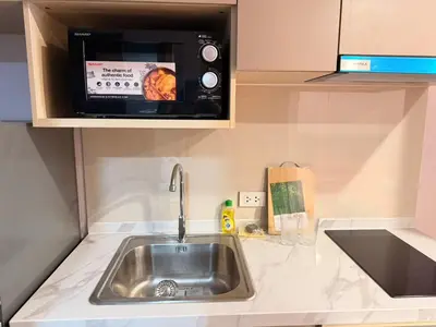 a kitchen with a sink and a microwave at Bangkok Condo Ramkhamhaeng in Sathani Ban Hua Mak