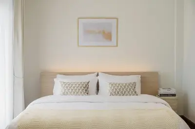 a bed with white sheets and pillows in a bedroom at Bhumidol Home near Don Muang Airport in Lak Si