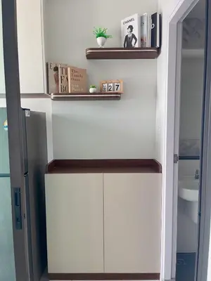 a kitchen with white cabinets and shelves on the wall at Wutthakat new room in Bangkok