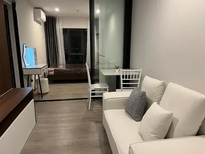 a living room with a white couch and a table at Wutthakat new room in Bangkok
