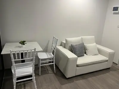 a living room with a white couch and a table at Wutthakat new room in Bangkok