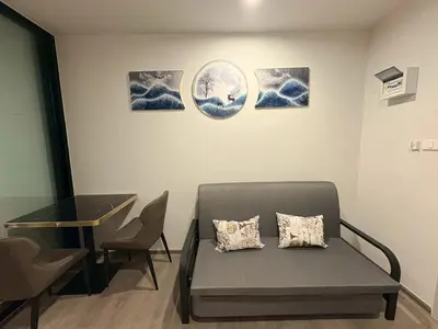 a room with a couch and a table and some pictures at Wutthakat new room in Bangkok