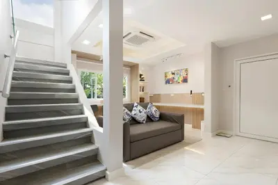 a living room with stairs and a couch at Bangkoks most beautiful modern villa centre in Bangkok