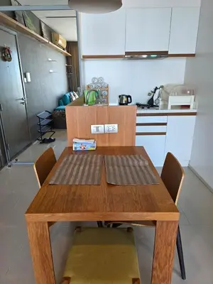 a wooden table and chairs in a kitchen at Chaophraya River high-rise river view apartment direct access to iconsiam Siam Square Chinatown 0 distance from BTS subway exit direct to Sathorn Silom Road Siam Square in Bangkok