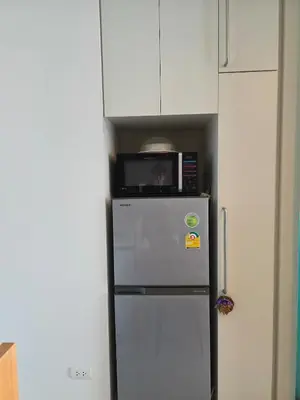 a microwave sitting on top of a refrigerator at Chaophraya River high-rise river view apartment direct access to iconsiam Siam Square Chinatown 0 distance from BTS subway exit direct to Sathorn Silom Road Siam Square in Bangkok