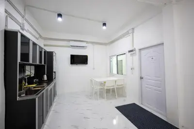 a white room with a table and a white door at ดอนเมือง 305 Near DMK Airport BTS Wat PhraSi in Bang Khen