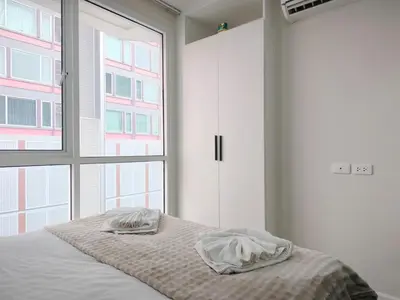a bedroom with a bed and a large window at Phahonyothin 35 Cozy 1BR Near BTS Chatuchak in Sathani Bang Khen