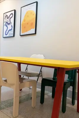 a yellow table in a room with chairs at Sadhu10BedBake in Bangkok