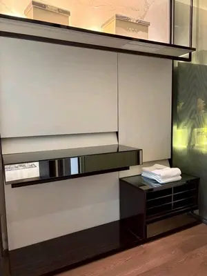 a room with a wall with shelves and a table at The Bangkok Thonglor in Bangkok