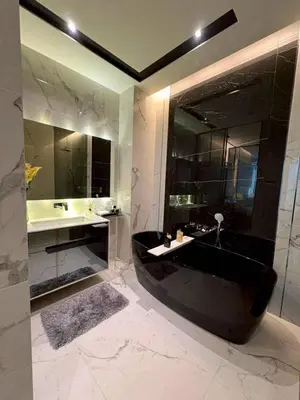a bathroom with a black tub and a sink at The Bangkok Thonglor in Bangkok