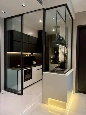 a kitchen with black and white cabinets and a counter at The Bangkok Thonglor in Bangkok