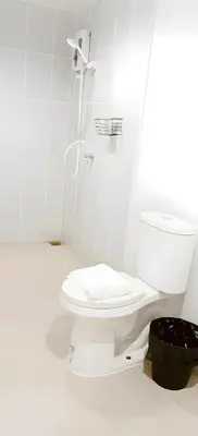 a white bathroom with a toilet and a shower at Snap Sukhumvit 1 - Bangkok City