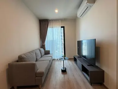 a living room with a couch and a flat screen tv at NUE District Rama 9 Condo in Bangkok