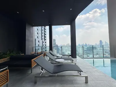 a room with chairs and a view of a city at NUE District Rama 9 Condo in Bangkok