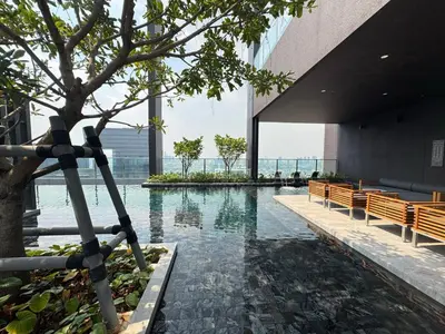 a pool in the middle of a building with benches at NUE District Rama 9 Condo in Bangkok