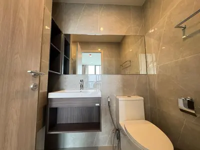 a bathroom with a sink and a toilet and a mirror at NUE District Rama 9 Condo in Bangkok