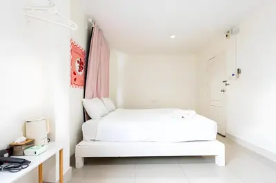 a white bedroom with a bed and a desk at XX Oh My Nap Sukhumvit 3 - นานาเหนือ in Makkasan