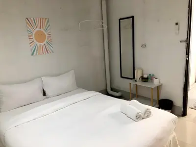 a white bed with two towels on top of it at XX Oh My Nap Sukhumvit 3 - นานาเหนือ in Makkasan