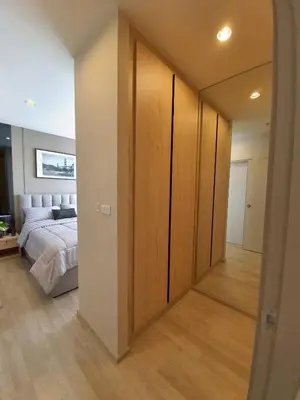 a bedroom with a bed and a large wooden closet at Idea Labs Luxury Condo Coworking spaces in Ban Khlong Samrong