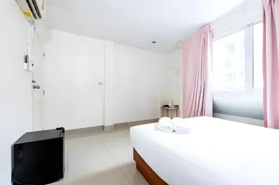 a white bedroom with a bed and a tv at Oh My Nap Sukhumvit Soi 3 - คลองเตยเหนือ in Makkasan