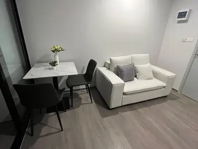 a living room with a white couch and a table at Wutthakat high-rise exterior view room in Bangkok