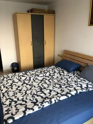 a bedroom with a bed with a black and white comforter at BTS skytrain Phra Khanong Happy Place 1bedroom with office set in Bangkok