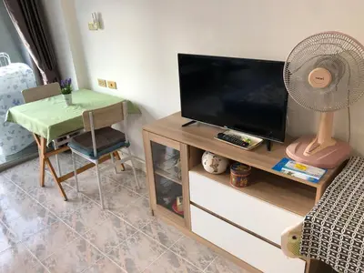 a living room with a tv and a table with a fan at BTS skytrain Phra Khanong Happy Place 1bedroom with office set in Bangkok