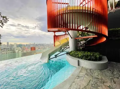 a swimming pool with a slide on the side of a building at Lovely home 2 in Ban Na Song
