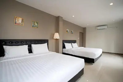 a hotel room with two beds with white sheets at Grand 3BR Townhouse in the Heart of BKK - Emsphere in Khlong Toei